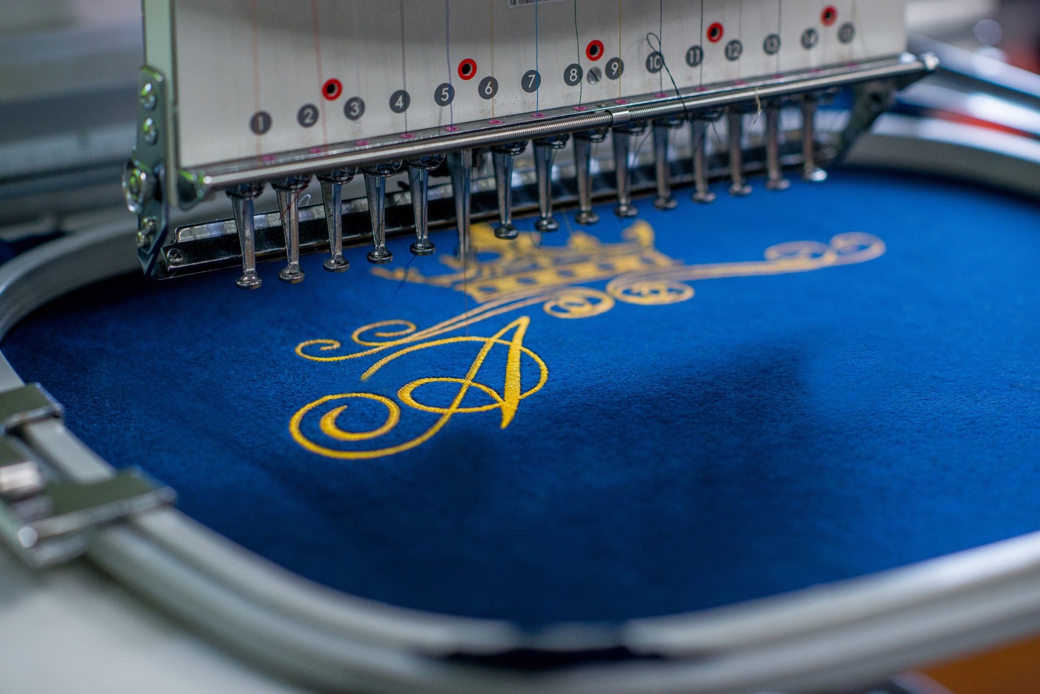 Broderie dorée sur textile bleu en machine